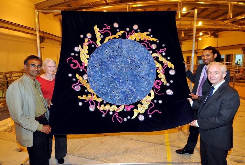 Prof. Venki Ramakrishnan, winner of the 2009 Nobel Prize for Chemistry, Anne Griffiths, the textile artist who designed the final art piece, and Dr Myron Smith, from Oxfordshire-based biopharmaceutical company Evotec who achieved the featured diffraction pattern at Diamond, and Prof. Gerd Materlik, Diamond’s Chief Executive, with the newly completed World's largest diffraction pattern