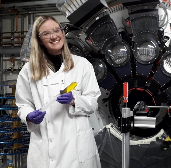 Dr Rebecca Rae on the I11 beamline, holding a Cr-containing liquid sample in a syringe. Image credit: Dr Caroline Kirk<br/>