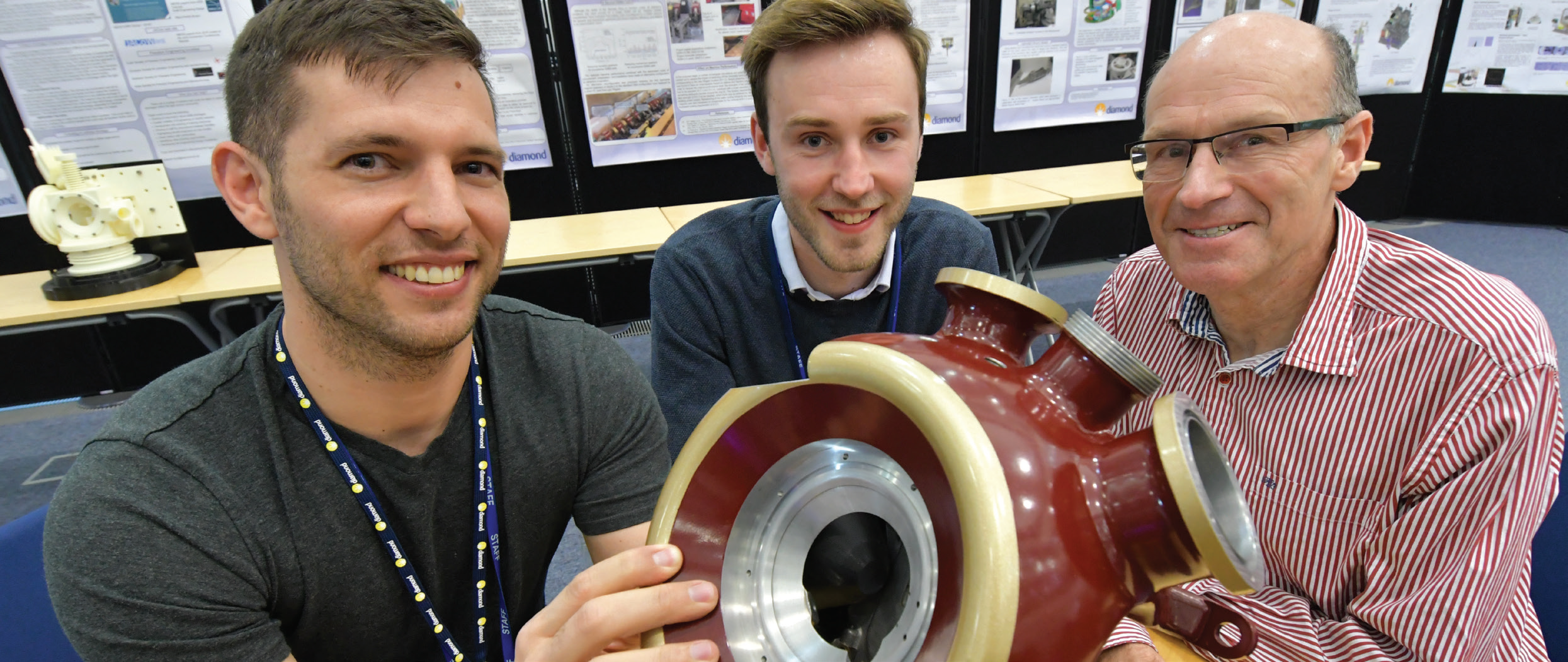 Pablo Sanchez Navarro, Frankie Bailey and Stewart Scott look at a 3D printed prototype vacuum vessel, to be used on beamline VMXm, during the Early Career Engineering School.