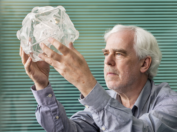 David Stuart is a biologist who studies viruses; how they infect, spread, and evolve, and how they can be treated with targeted medicines. He is holding a sculpture of the hand, foot and mouth virus, a childhood disease that infects 1.6 million people each year. David solved the structure of the virus at Diamond Light Source and has since created a potential cure for this currently untreatable disease. His work may also lead to new treatments for other diseases, such as polio.