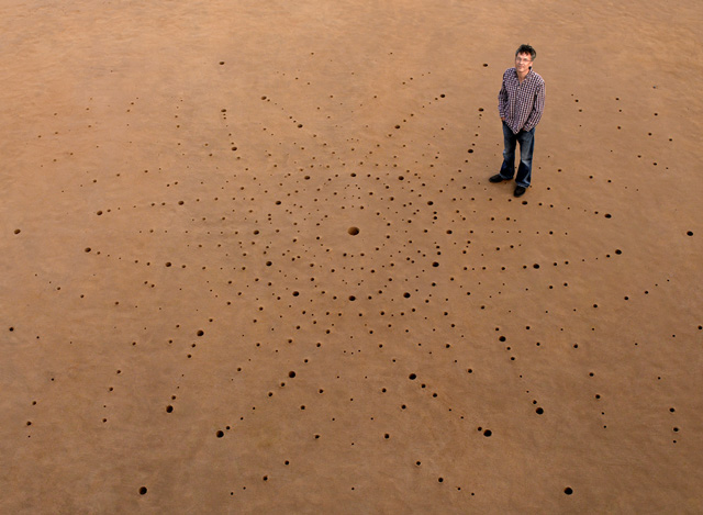David Keen studies crystal structures that behave in unusual ways when their atoms become disordered; they might unexpectedly melt, change into a glass, or start conducting electricity. Hundreds of holes were dug in the sand in Porthcawl beach in South Wales to portray the neutron diffraction pattern from a quartz crystal.  Quartz is one of the minerals David has studied and is a common component of sand.