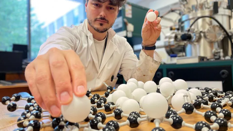 Dr Emerson Kohlrausch demonstrating how atoms are guided and bonded to precise locations on a carbon surface. Nottingham University