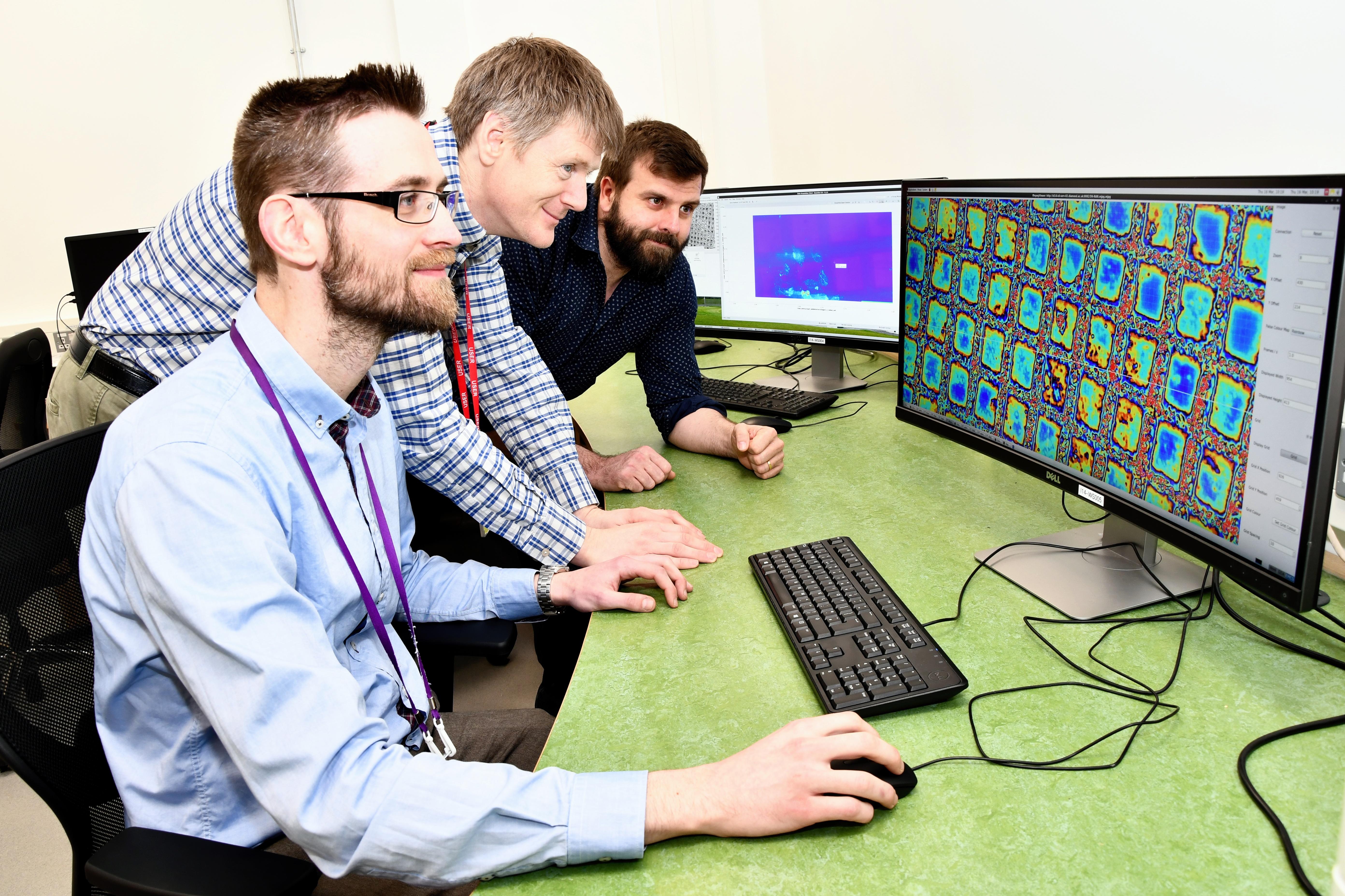 Principal beamline scientist Dr Paul Quinn (right), with first users Dr Peter Ellis (centre) and Dr Manfred Schuster (left) in the I14 control cabin.