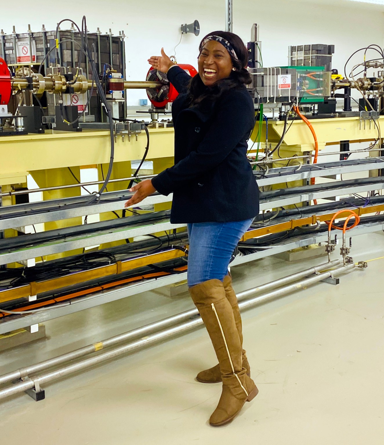 Gugulethu Nkala, energy materials PhD student at the University of the Witwatersrand, South Africa, on a workshop tour of Diamond in March 2020. Here Gugu is looking at the large red magnets that are part of the linear accelerator at Diamond on a visit to the Diamond synchrotron funded by the GCRF START grant.  The electron beams travel through the linear accelerator and are used to investigate the samples provided by the scientists for their experiments. Photo credit: Gugulethu Nkala.
